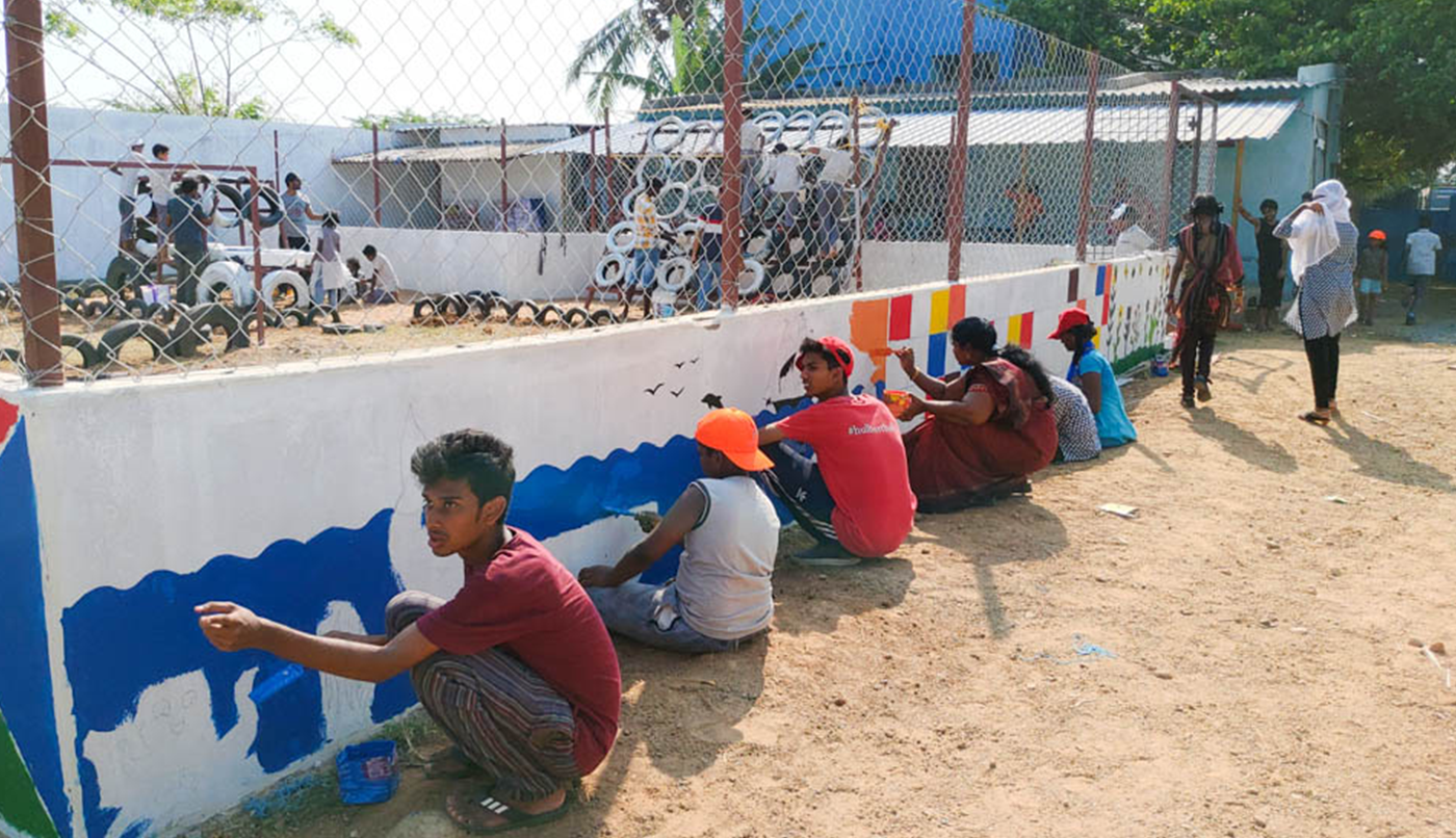 Volunteers, students, and a teacher painting together!
